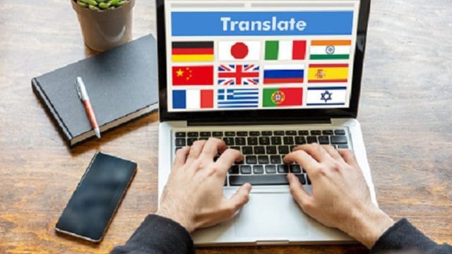 Man working on a laptop with the word translate on the computer screen