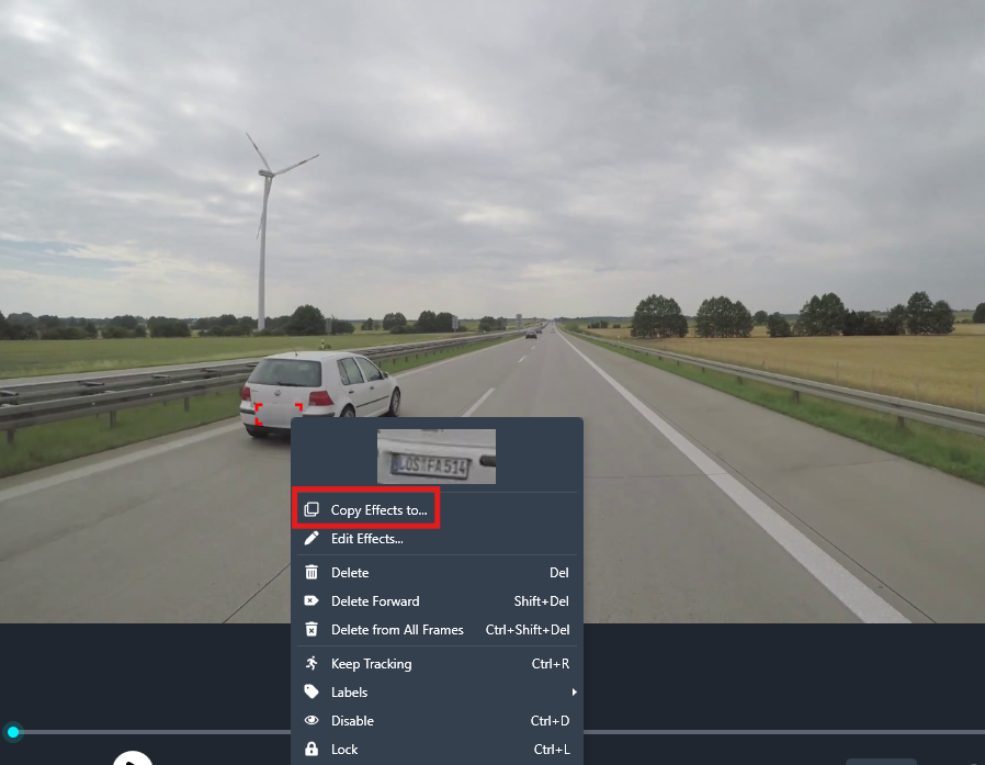 Highway scene with a white car on the left shoulder and a wind turbine on a grassy field, shown inside video editing software with a context menu open (Copy Effects to...)